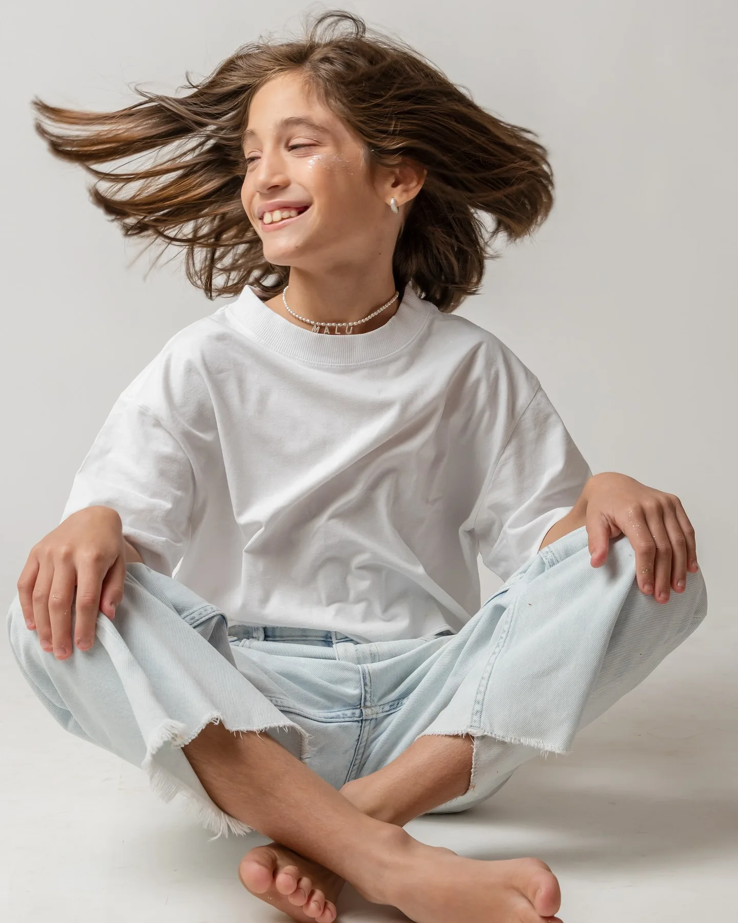 Criança sorrindo em um retrato com o cabelo em movimento